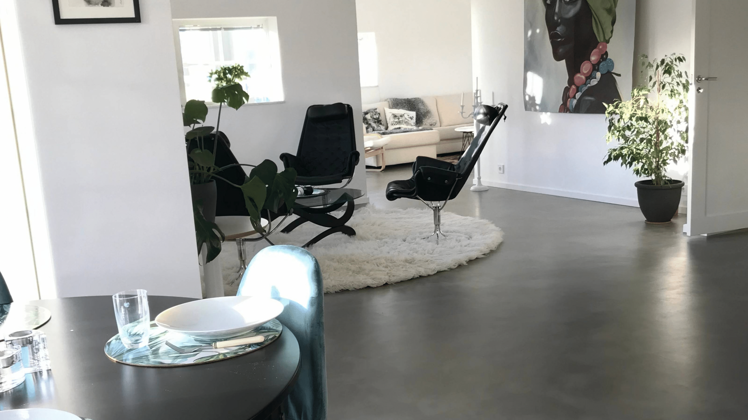 Ett vardagsrum med estetiskt och vackert svart microcementgolv.